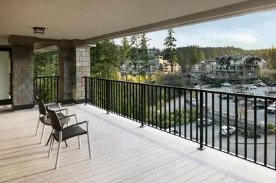 a balcony with two chairs and a view of a harbor at The Westin Bear Mountain Resort & Spa, Victoria in Victoria