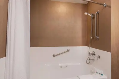 a bathroom with a shower with a white shower curtain at The Westin Bear Mountain Resort & Spa, Victoria in Victoria