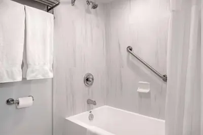 a white bathroom with a tub and a sink at Days Inn by Wyndham Victoria Uptown in Victoria