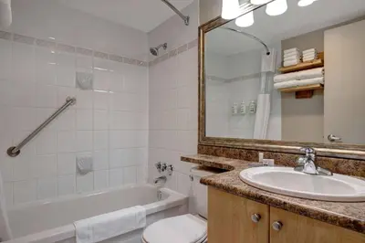 a bathroom with a sink and a tub and a toilet at Days Inn by Wyndham Victoria Uptown in Victoria