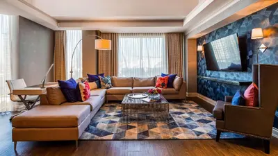 a living room with a couch and a tv at Georgian Court Hotel, WorldHotels Elite in Vancouver
