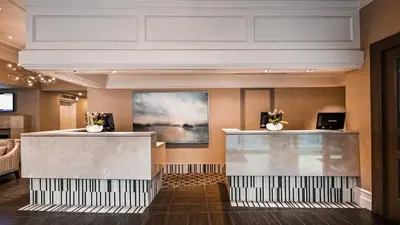 a lobby with a reception counter and a painting at Georgian Court Hotel, WorldHotels Elite in Vancouver