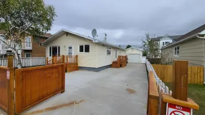 a house with a wooden fence and a driveway at YK Aurora in Yellowknife
