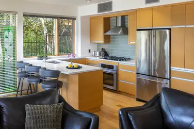 a kitchen with wooden cabinets and a stainless steel refrigerator at Brentwood Bay Resort & Spa in Brentwood Bay