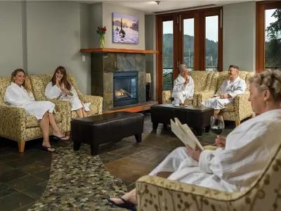 a group of people sitting in a living room with a fireplace at Brentwood Bay Resort & Spa in Brentwood Bay