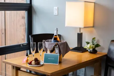 a table with a bottle of wine and wine glasses at Brentwood Bay Resort & Spa in Brentwood Bay