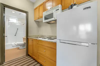 a kitchen with wooden cabinets and a white refrigerator at Best Western King George Inn & Suites in Surrey