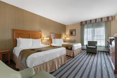 a hotel room with two beds and a chair at Best Western King George Inn & Suites in Surrey