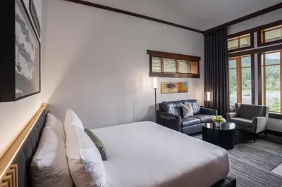 a hotel room with a bed and a chair at Nita Lake Lodge in Whistler
