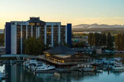 a large building with a marina with boats in the water at Radisson Blu Vancouver Airport Hotel & Marina in Richmond