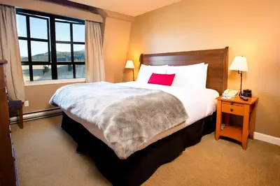 a hotel room with a large bed and a window at Sundial Hotel in Whistler