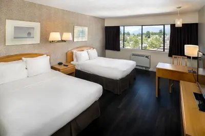 a hotel room with two beds and a desk at Cassandra Hotel in Vancouver