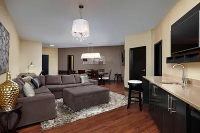 a living room with a couch and a kitchen at Four Points by Sheraton Hotel & Suites Calgary West in Calgary