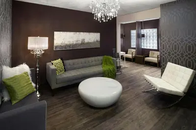 a living room with a couch and a table and chairs at Four Points by Sheraton Hotel & Suites Calgary West in Calgary