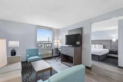 a hotel room with a bed and a television at Emerald Hotel & Suites Calgary Airport in Calgary