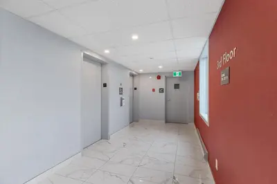 an empty hallway of an office with a red wall at Emerald Hotel & Suites Calgary Airport in Calgary