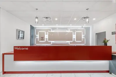 a waiting room with a welcome sign on the wall at Emerald Hotel & Suites Calgary Airport in Calgary