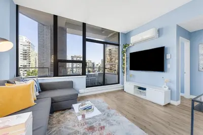 a living room with a couch and a tv at Best Location Downtown Chic Suites in Vancouver