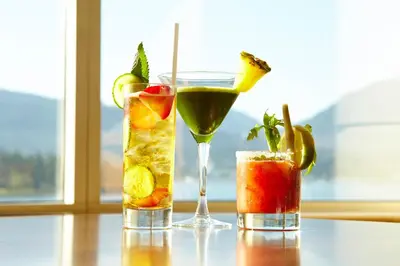 three cocktails sitting on a table next to a window at Pan Pacific Vancouver in Vancouver