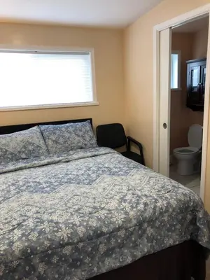 a bedroom with a bed and a window and a toilet at Shady Willow Guest House - SMALL Indipendent Units with Seperate Entrance for Travellers in Chilliwack