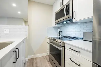 a kitchen with white cabinets and a stove top oven at The Aspens by Outpost Whistler in Whistler
