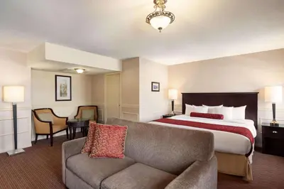 a hotel room with a bed and a couch at The Plaza Hotel Downtown, Trademark Collection by Wyndham in Kamloops