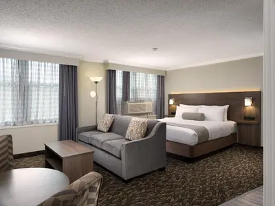 a hotel room with a bed and a couch at BEST WESTERN PLUS Carlton Plaza Hotel in Victoria