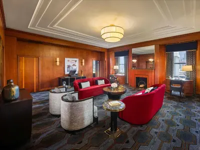 a living room with red furniture and a fireplace at Fairmont Hotel Vancouver in Vancouver
