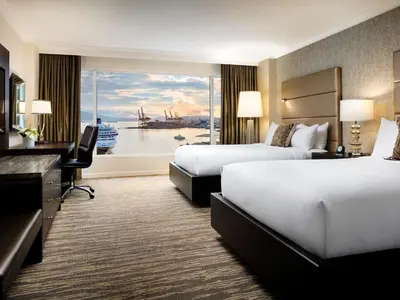 a hotel room with two beds and a large window at Fairmont Waterfront in Vancouver