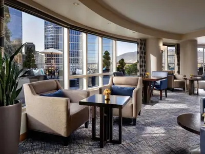 a hotel lobby with chairs and tables and large windows at Fairmont Waterfront in Vancouver