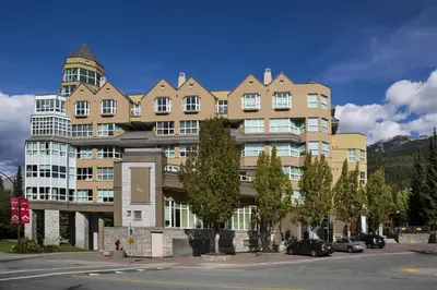 a large apartment building with cars parked in a parking lot at Le Chamois by Whistler Premier in Whistler