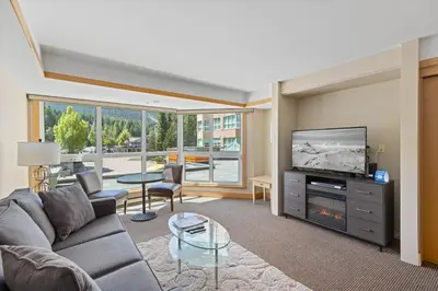 a living room with a couch and a flat screen tv at Le Chamois by Whistler Premier in Whistler