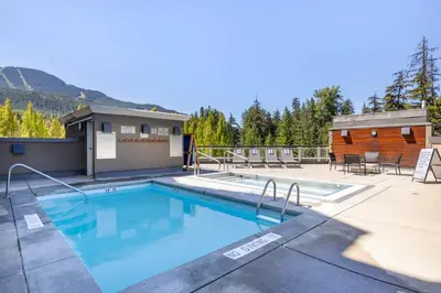 a swimming pool on a patio with a cabin at Le Chamois by Whistler Premier in Whistler