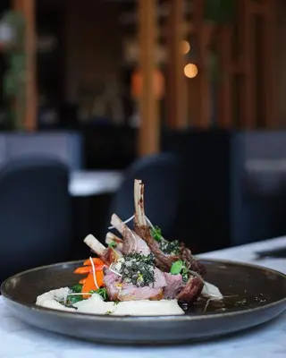 a plate of food with meat and vegetables on a table at Oswego Hotel in Victoria