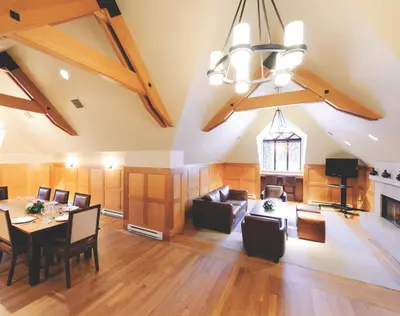 an attic living room with a table and chairs at Pan Pacific Whistler Mountainside in Whistler