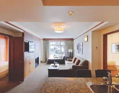 a living room with a couch and a tv at Pan Pacific Whistler Village Centre in Whistler