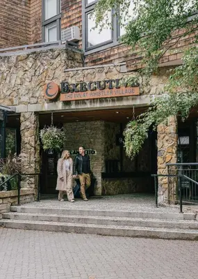 a man and woman walking into the entrance to a building at Executive Inn Whistler in Whistler