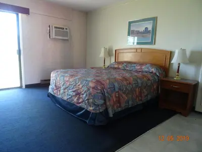 a hotel room with a bed and a window at Hospitality Inn in Kamloops
