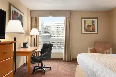 a hotel room with a desk and a bed and a window at Days Inn by Wyndham Edmonton Downtown in Edmonton