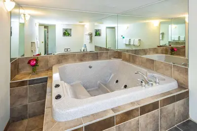 a large tub in a bathroom with a large mirror at Comfort Inn & Suites in Edmonton