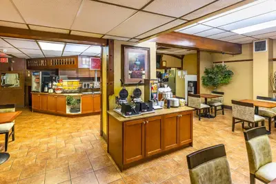 a restaurant with a counter and tables and chairs at Comfort Inn & Suites in Edmonton