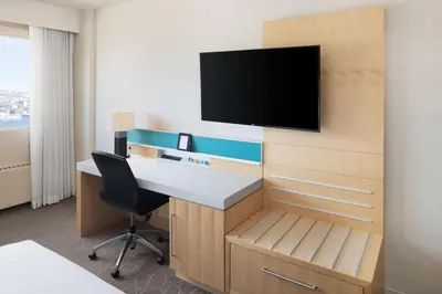 a room with a desk and a tv on a wall at Delta Hotels by Marriott Edmonton South Conference Centre in Edmonton