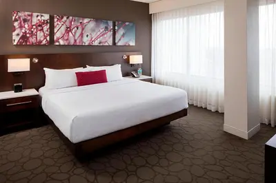 a bedroom with a large white bed with red pillows at Delta Hotels by Marriott Edmonton South Conference Centre in Edmonton
