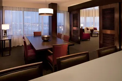 a room with a table and chairs and a living room at Delta Hotels by Marriott Edmonton South Conference Centre in Edmonton