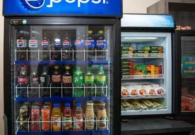 a refrigerator filled with lots of bottles of soda at Campus Tower Suite Hotel in Edmonton