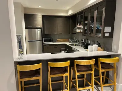 a kitchen with a counter with three stools at Luxury accomodation in West Vancouver in West Vancouver
