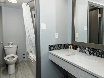 a bathroom with a toilet and a sink and a mirror at Paradise Inn & Conference Centre in Grande Prairie