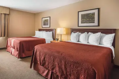 a hotel room with two beds with red sheets at Quality Hotel & Conference Centre in Fort McMurray
