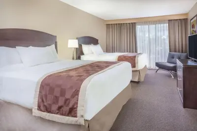 a hotel room with two beds and a television at Baymont by Wyndham Red Deer in Red Deer