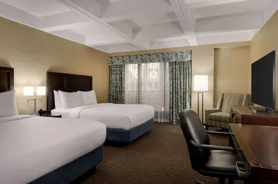 a hotel room with two beds and a desk at Wyndham Edmonton Hotel and Conference Centre in Edmonton